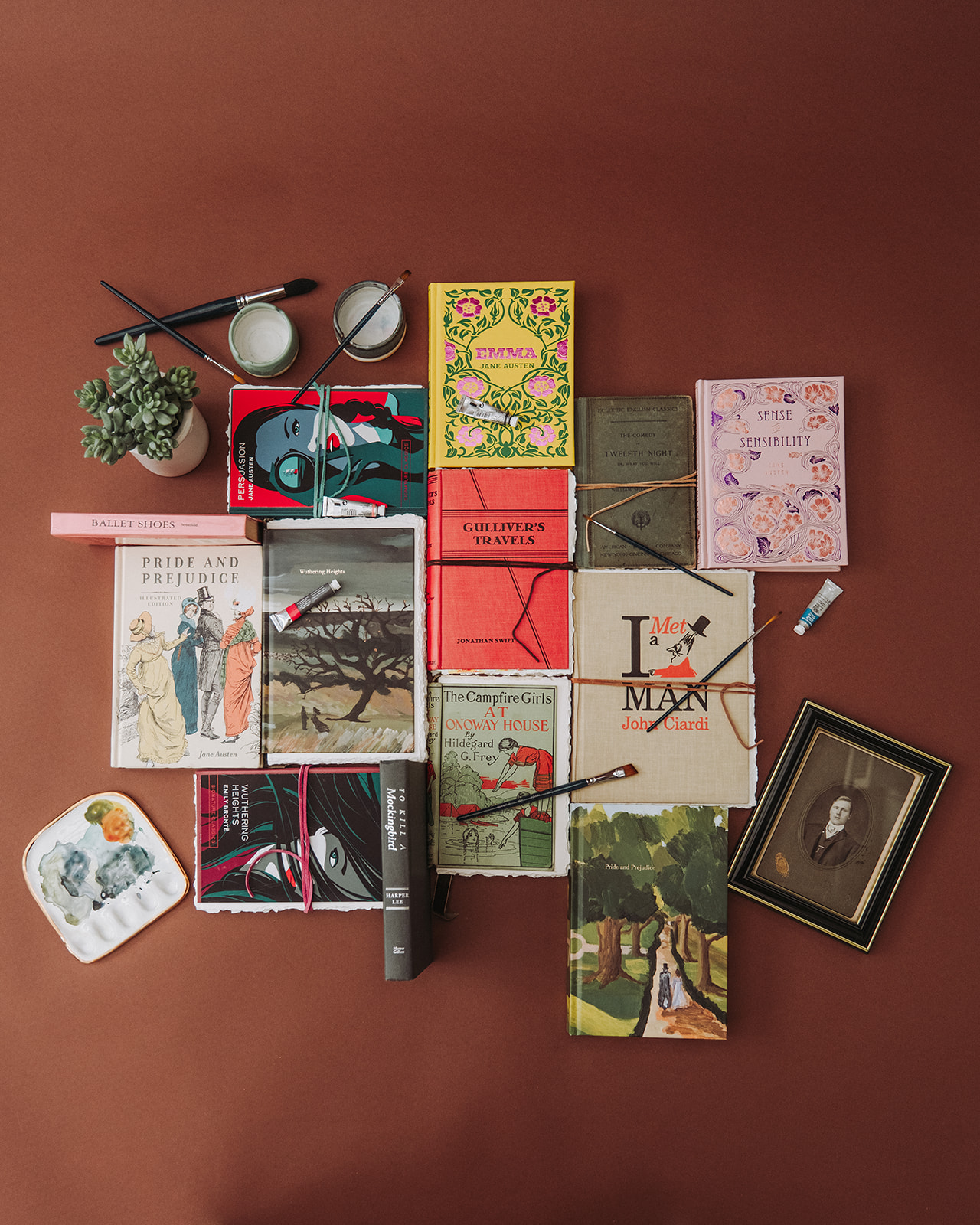 Collection of artist books with paint brushes and supplies